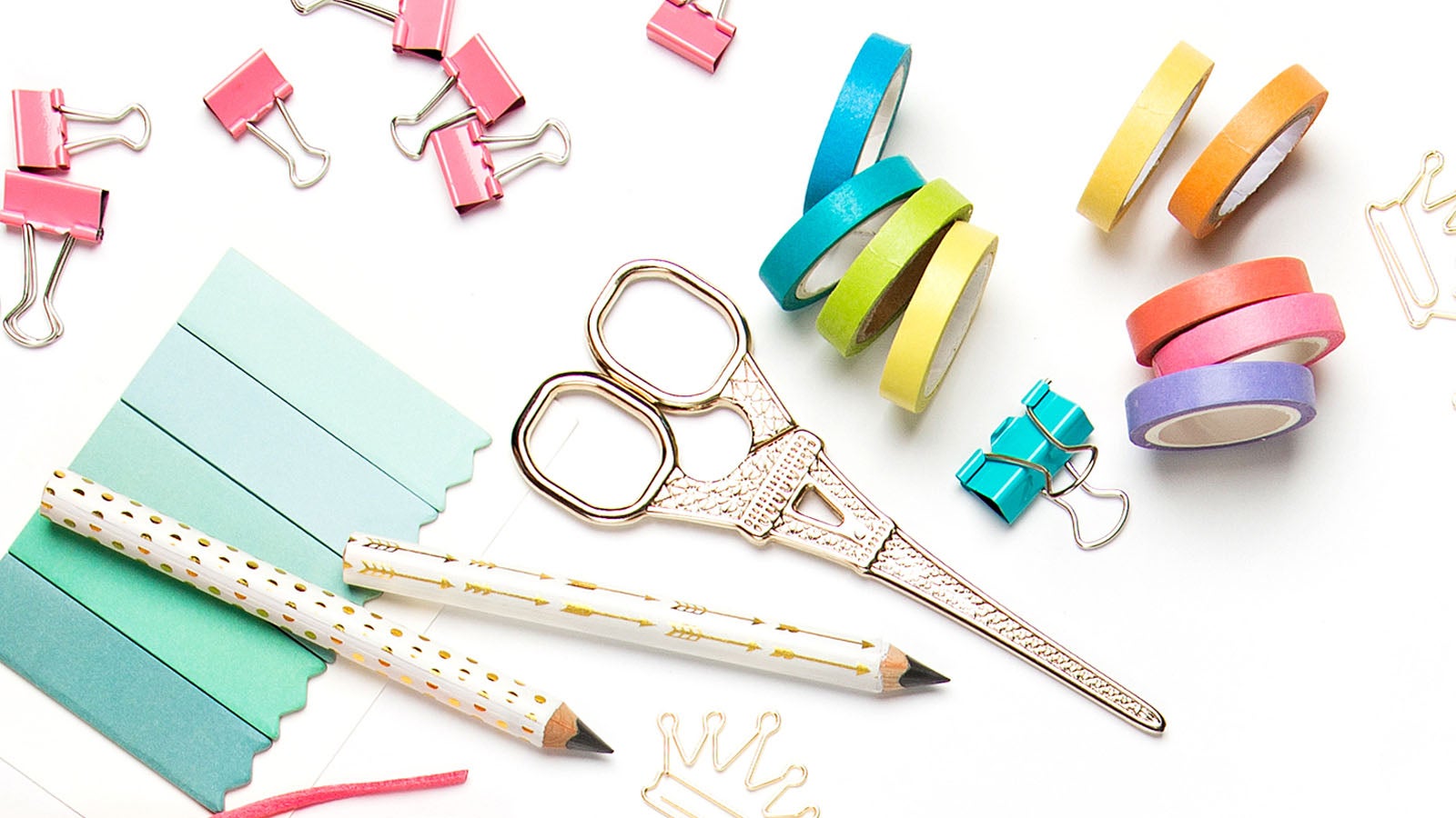A selection of stationary including pencils, washi tape and bulldog clips in bright colours. 