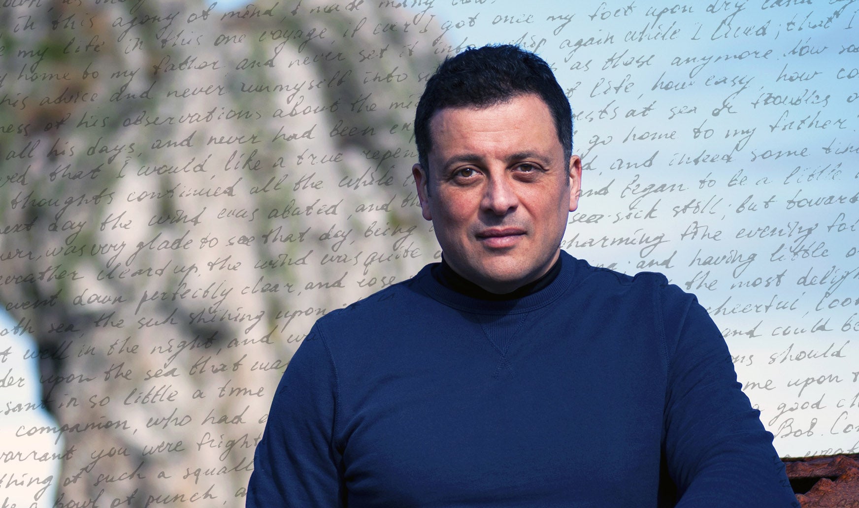 Adam Hamdy on a beach with a background of words