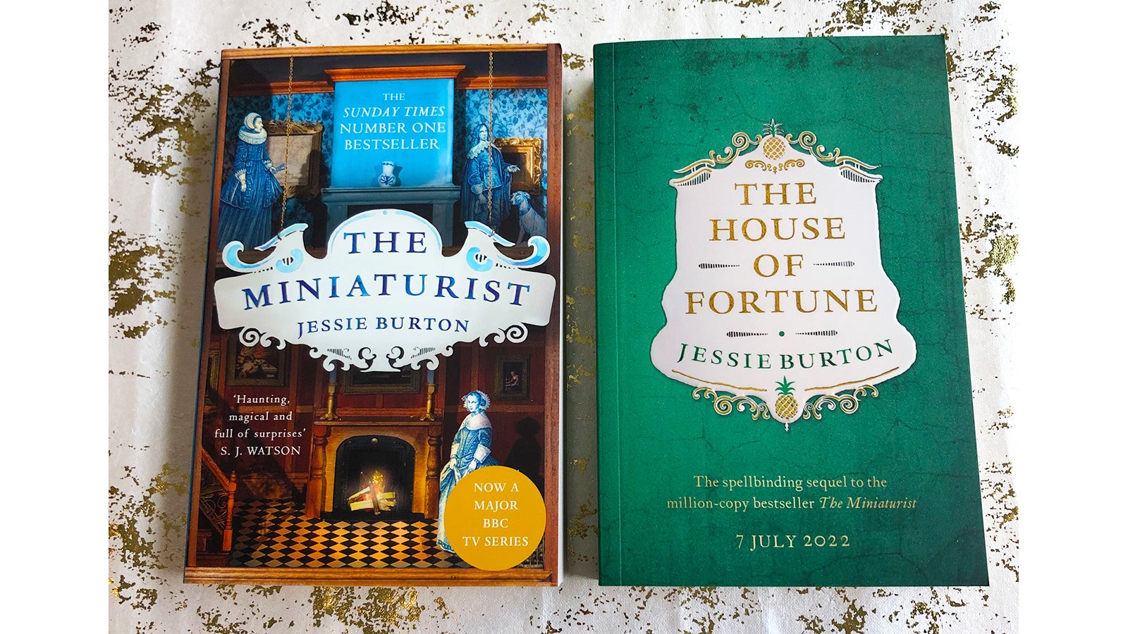 A copy of The Miniaturist next to a proof copy of The House of Fortune on a white and gold background.