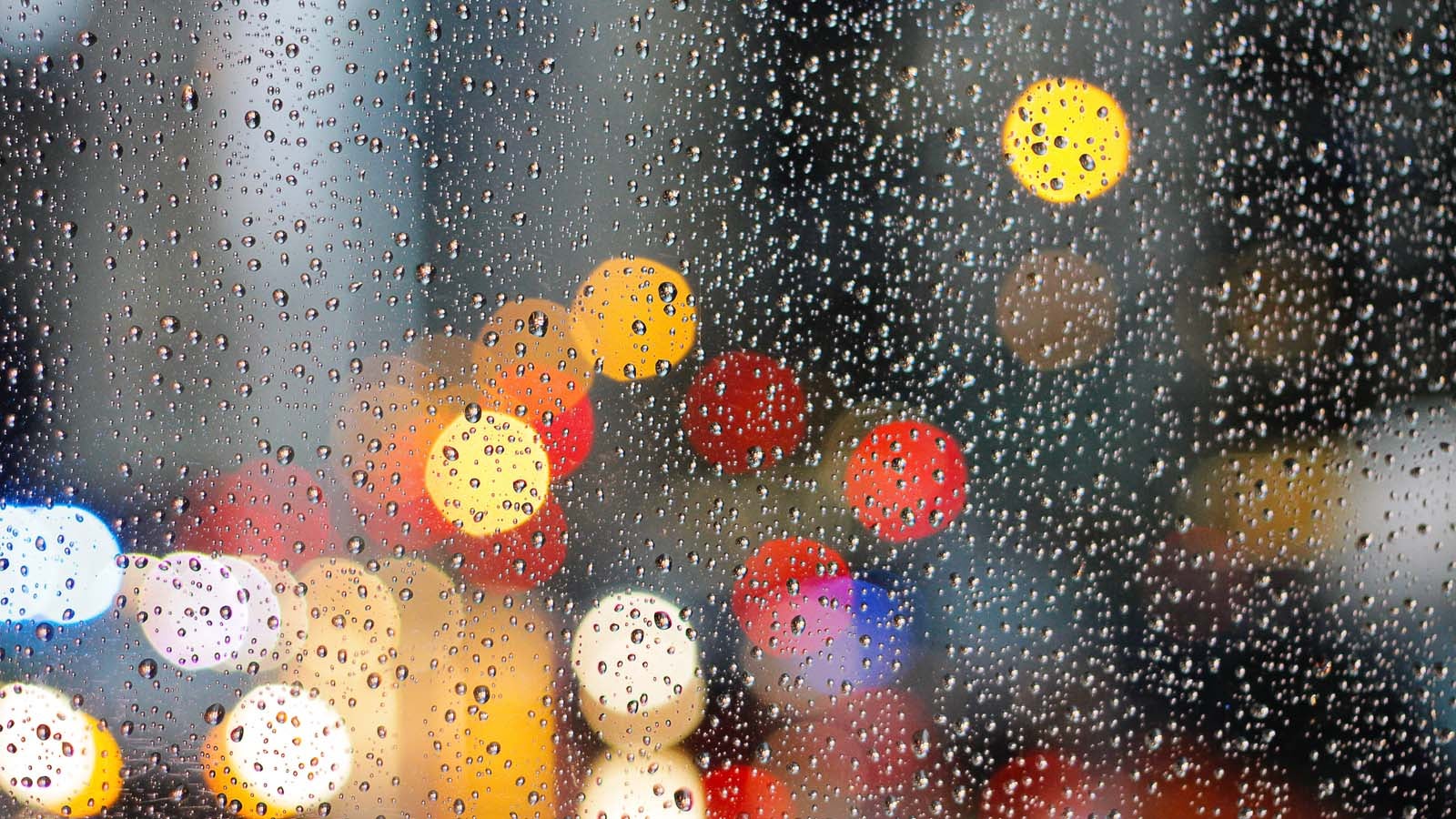window with water droplets and blurred city lights
