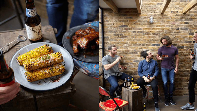 Joe Wicks with friends, corn on cobs, BBQ ribs and beer on a wooden surface