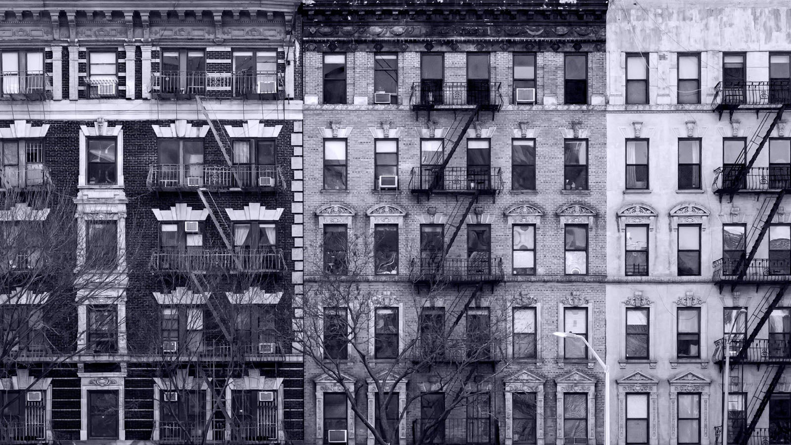 A black and white photograph of New York apartment buildings