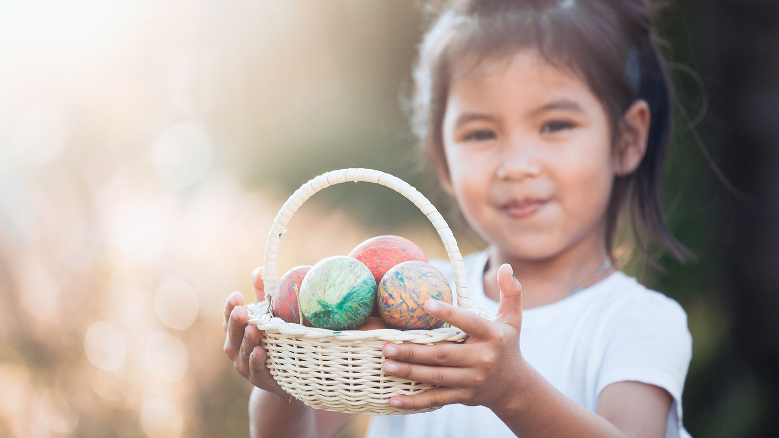 Girl holding basket of Easter eggs