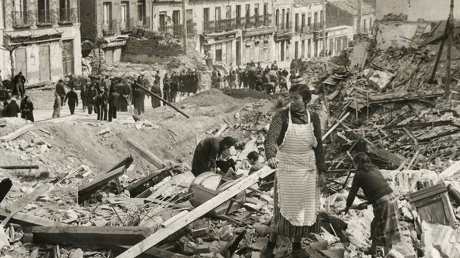 Black and white photograph of a Spanish woman standing on top of her demolished home