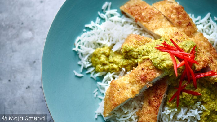 Joe Wicks's Chicken Katsu served on a bed of rice on a blue china plate.