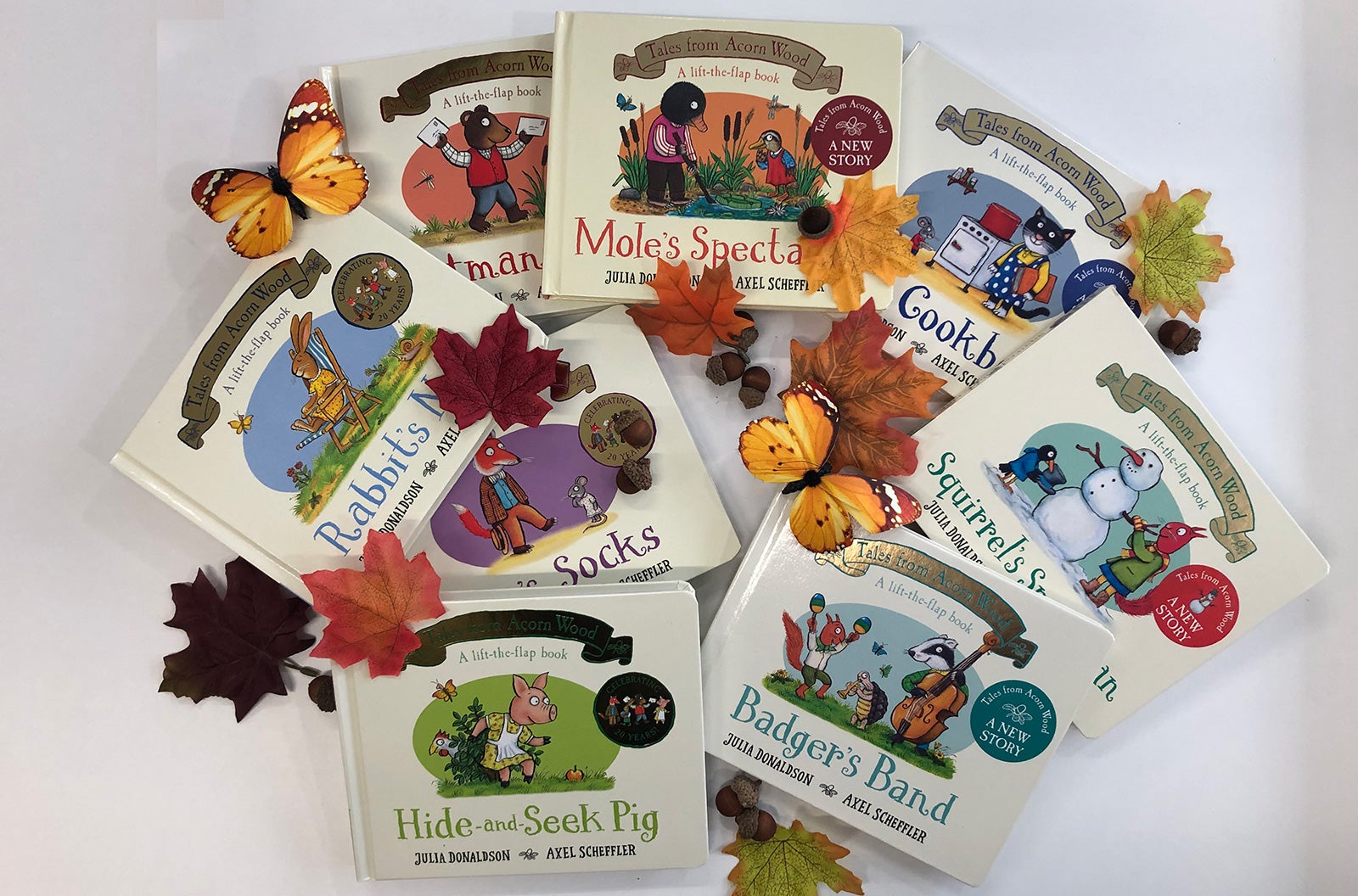 All eight titles from the Tales from Acorn Wood series arranged with leaves, butterflies and acorns.