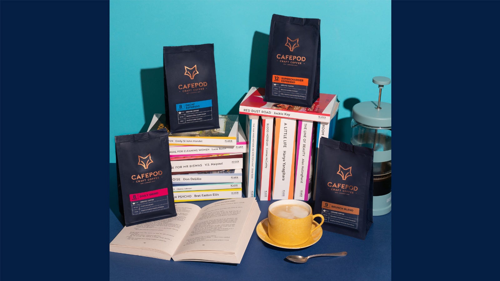 A photo of books and coffee in front of a blue background.