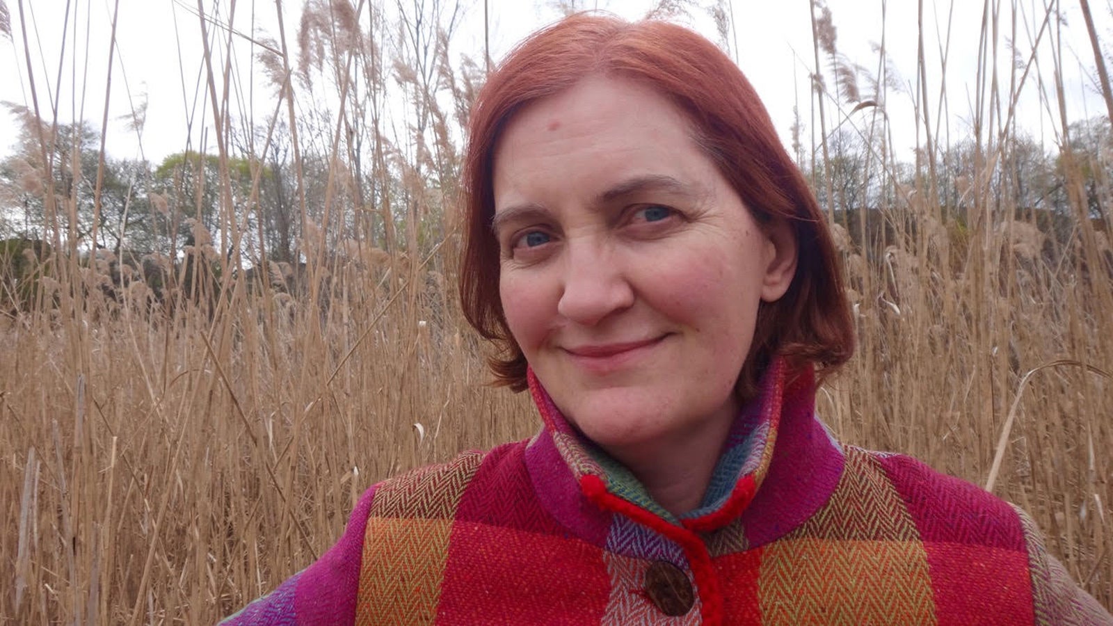 Emma Donoghue smiles in a field of long grass