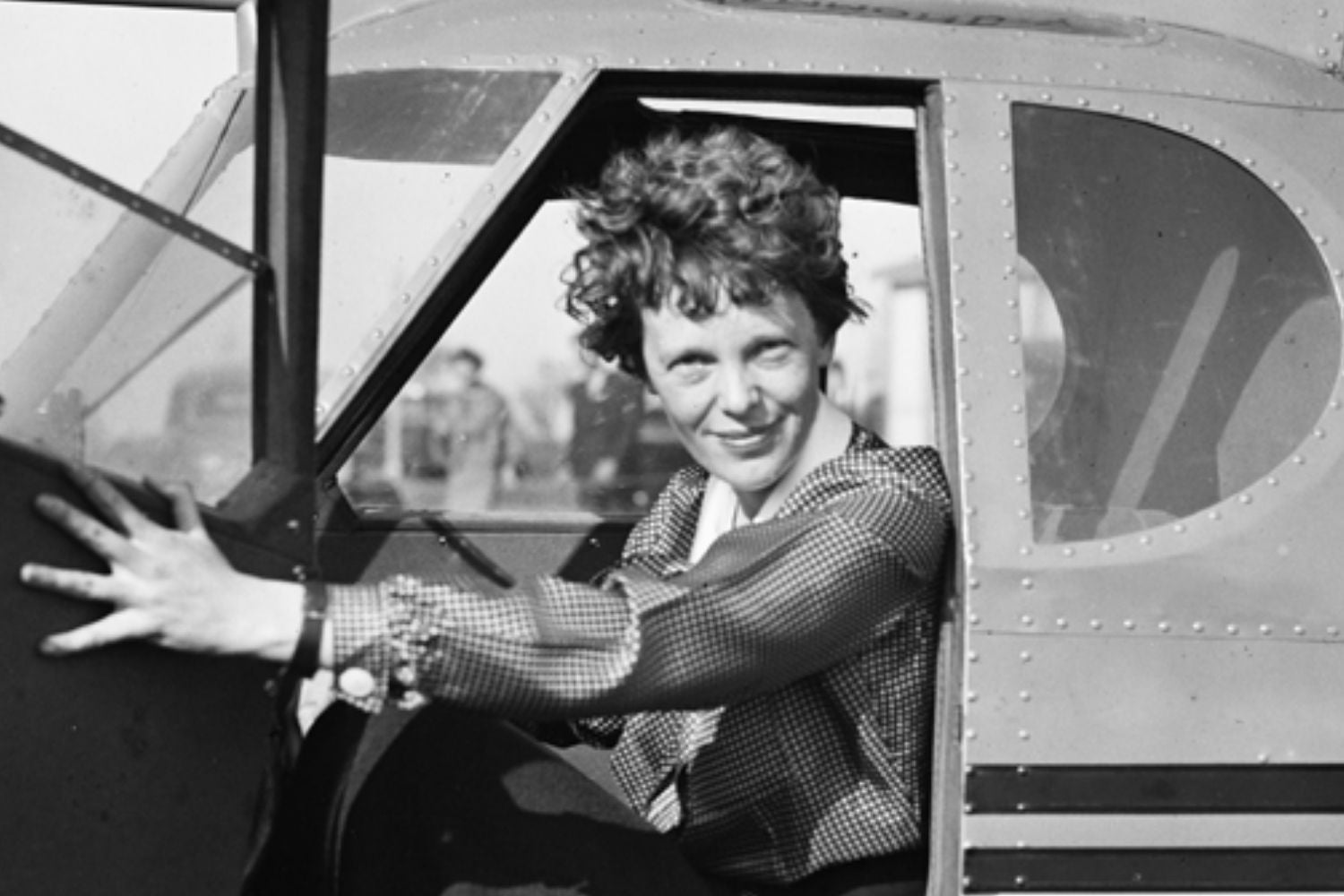 amelia earhart sitting in cockpit black and white photo