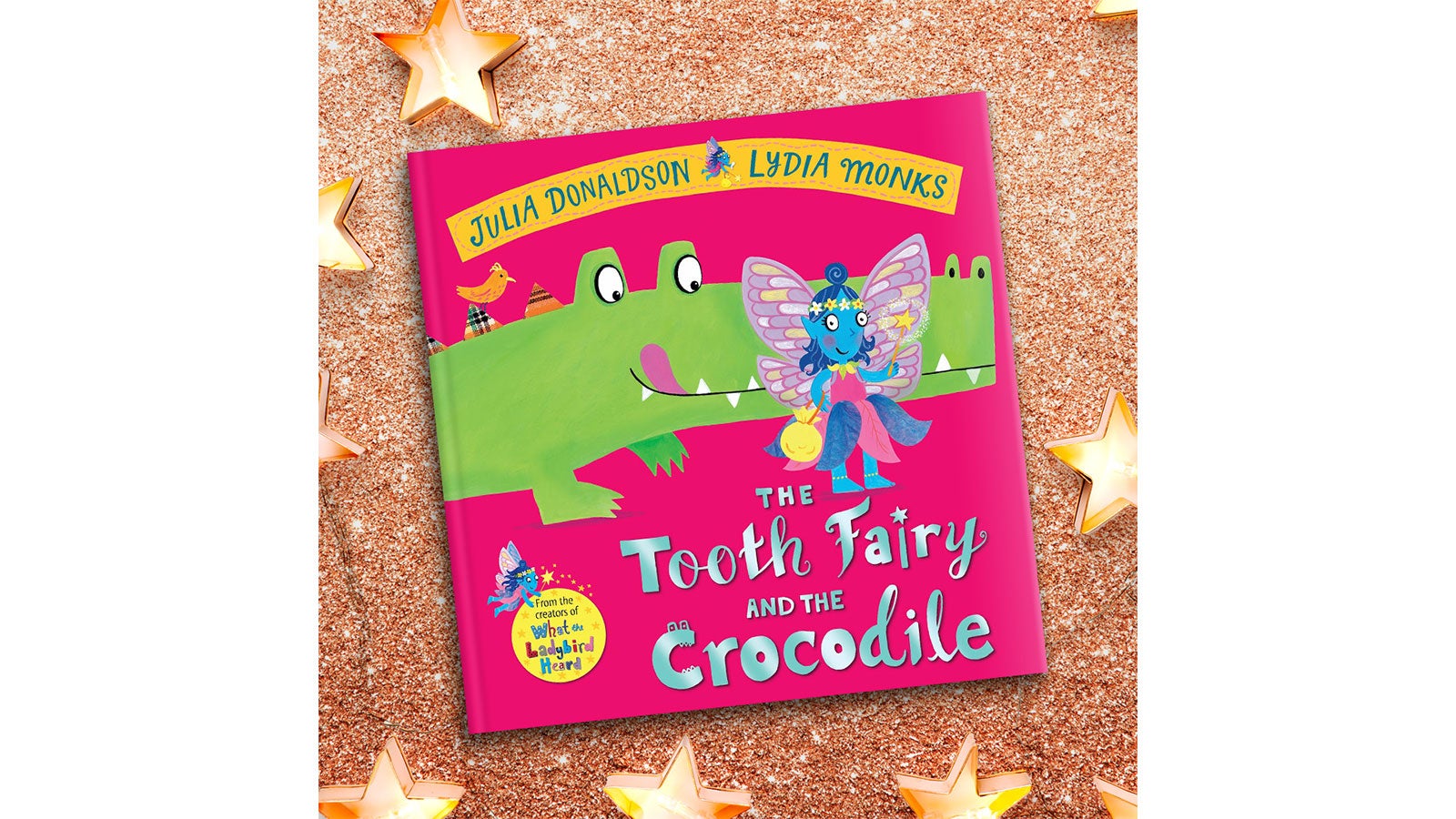 The Tooth Fairy and the Crocodile book cover on a gold sparkly background with stars