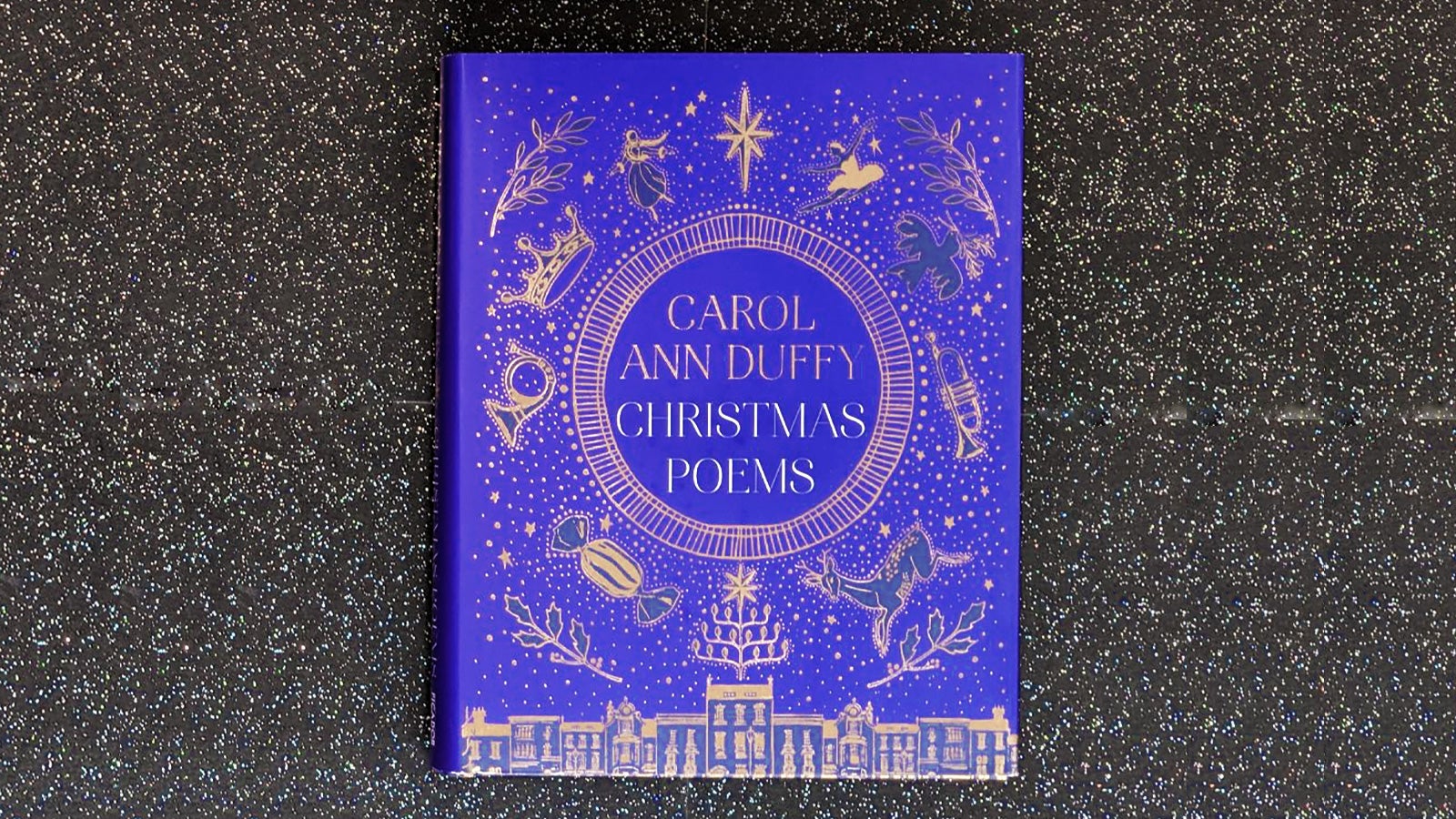 A copy of Christmas Poems by Carol Ann Duffy sits on a starry background.