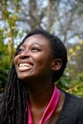 A photograph on Helen Oyeyemi smiling with woodland in the background