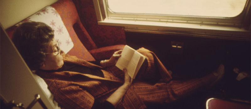 Sepia photograph of woman reading in a train carriage 