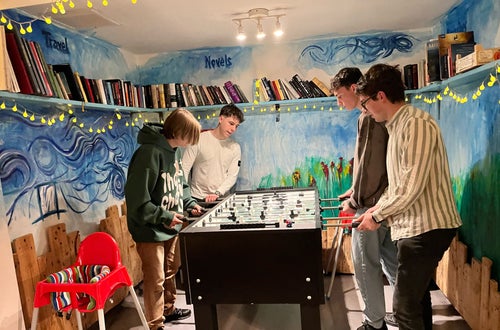Momento di relax per gli studenti della Scuola Alberghiera Cesare Ritz di Merano in una sala ricreativa con biliardino e libreria, un ambiente stimolante per la crescita personale. Momento di relax per gli studenti della Scuola Alberghiera Cesare Ritz di Merano in una sala ricreativa con biliardino e libreria, un ambiente stimolante per la crescita personale.