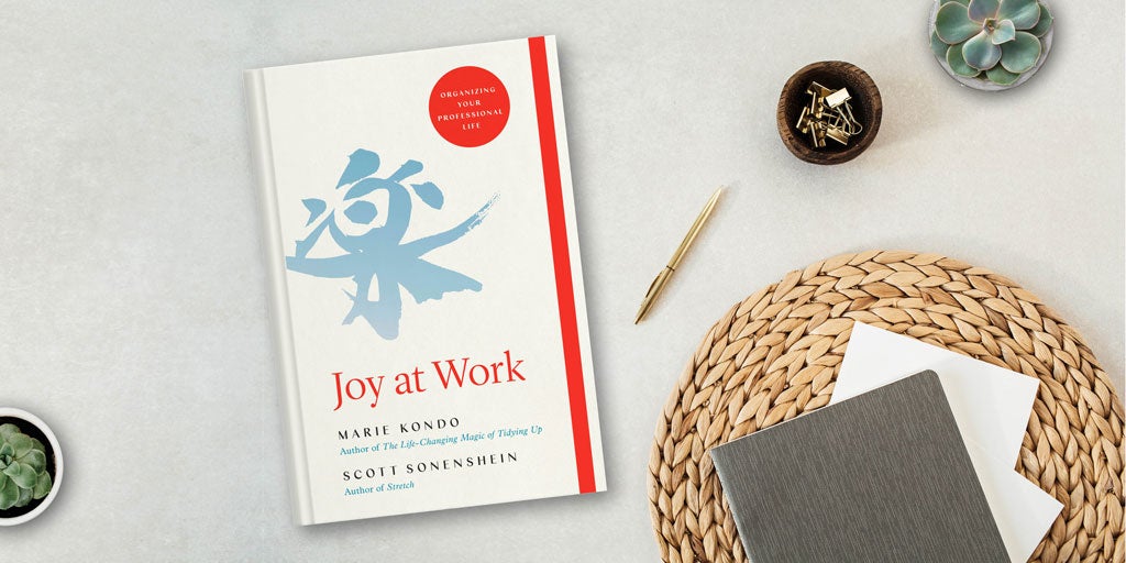 Photo of a desk with Joy at Work by Marie Kondo on it and a pen and notebook