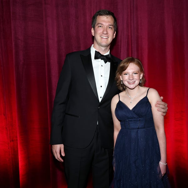 The DKMS donor William Dossett, wearing a black tuxedo, stands beside the 13-year-old acute myeloid leukemia survivor Madison Adams, wearing a navy blue gown. They are both smiling in front of a red curtain backdrop at the DKMS New York Gala 2025. The DKMS donor William Dossett, wearing a black tuxedo, stands beside the 13-year-old acute myeloid leukemia survivor Madison Adams, wearing a navy blue gown. They are both smiling in front of a red curtain backdrop at the DKMS New York Gala 2025.