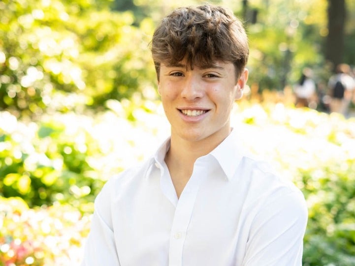 The patient Max is wearing a white shirt and smiling gently. A green forest can be seen in the background. The patient Max is wearing a white shirt and smiling gently. A green forest can be seen in the background.