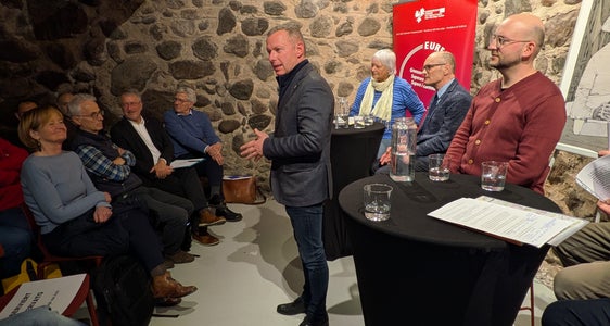 Il segretario generale dell'Euregio Christoph von Ach (in piedi, al centro della foto) ha fatto riferimento all'Anno dei musei dell'Euregio 2025, che con il motto “Guardare oltre” guarda al tempo di Gaismair e ben oltre. (Foto: Euregio/Armin Gluderer)