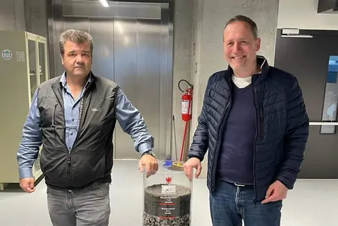 Landesrat Massimo Bessone mit Volkmar Mair, Direktor des Amtes für Geologie und Baustoffprüfung mit einem Zylinder voller Baustoffe für Straßenbau. (Foto: LPA)