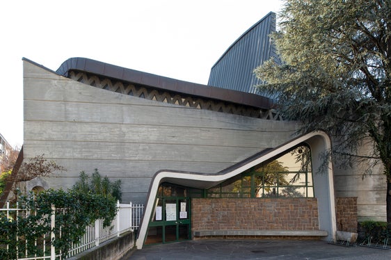 La superficie in calcestruzzo delle pareti esterne è segnata da strisce trasversali e sormontata da elementi di copertura a forma di vele (Foto: ASP/Alexa Rainer)