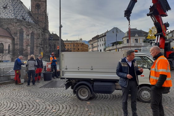 L'assessore alle Foreste Luis Walcher (secondo da destra) dialoga con Toni Kerschbaumer, della Giardineria comunale, che oggi attendeva l'ancoraggio professionale del suo 32esimo albero di Natale in piazza Walther. (Foto: USP/Maja Clara)
