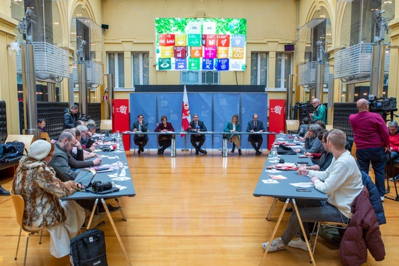 Un'immagine della conferenza stampa con il presidente Kompatscher (al centro) e i rappresentanti dei media: gli Obiettivi di Sviluppo Sostenibile delle Nazioni Unite (schermo visibile sopra il podio) sono alla base degli obiettivi della Provincia di Bolzano. (Foto: ASP/Fabio Brucculeri)