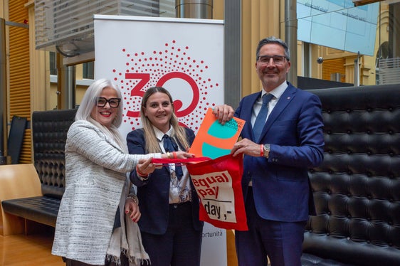 Als erste Amtshandlung haben Präsidentin Oberhammer (Mitte) und Vizepräsidentin Mazzardis (links) Landeshauptmann Kompatscher anlässlich des heutigen Equal Pay Day eine leere rote Tasche überreicht, die in den kommenden fünf Jahren mit konkreten Verbesserungen für die Situation der Frauen gefüllt werden solle. (Foto: LPA/Greta Stuefer)