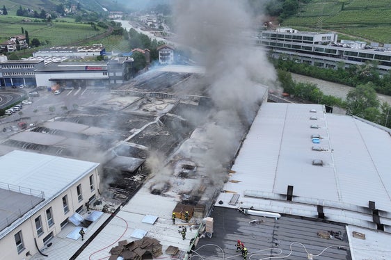 Die Berufsfeuerwehr analyisiert Usache und Dimensionen der Ausbreitung des Brandes am Sitz der Alpitronic am Mitterweg am Bozner Bozen, auch mit Hilfe von Drohnenaufnahmen; das Bild zeigt die Lage heute gegen Mittag. (Foto: LPA/Berufsfeuerwehr)