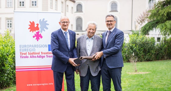 Treffen in Innsbruck: Die Landeshauptleute Anton Mattle (Tirol, links) und Arno Kompatscher (Südtirol, rechts) mit dem Stifter, dem Tiroler Landeshauptmann a. D. Wendelin Weingartner und dem Preis, einer Skulptur des Künstlers Lois Anvidalfarei. (Foto: Journalismusfest/Alena Klinger)