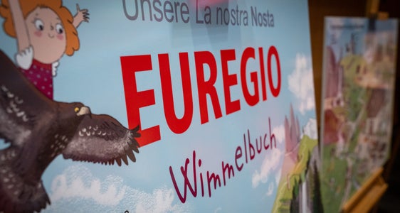 Auf Schautafeln wurde das Wimmelbuch während der Sitzung der Euregio-Versammlung vorgestellt. (Foto: Land Tirol/Neuner)