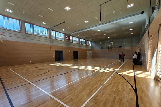 Die neue Turnhalle in der Grundschule Steinegg erstreckt sich über drei Stockwerke und verfügt auch über eine Tribüne. Sie wird sowohl von der Schule als auch von den örtlichen Vereinen genutzt. An der Oberfläche bietet die neue Struktur Platz für Parkplätze und den Markt bzw. diverse Veranstaltungen. (Foto: LPA/Ursula Pirchstaller)