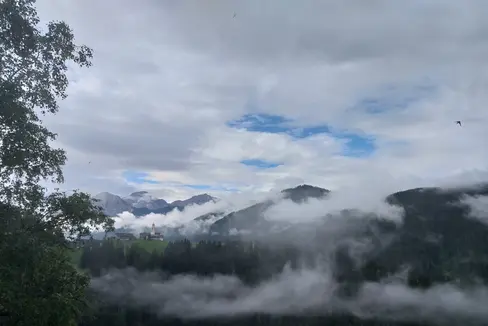 Juli am Berg: im Bild der Blick von Enneberg-Pfarre, La Pli de Mareo, auf den Weiler Curt, Hof, am Sonntag, 18. Juli, in der Früh. (Foto: LPA/Maja Clara)