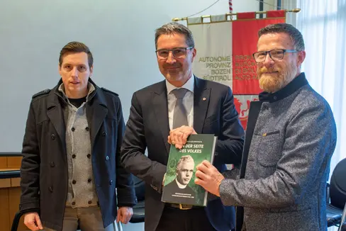 Der Landeskommandant des Schützenbundes Seppi (r.) und Geschäftsführer Zemmer (l.) überreichten Landeshauptmann Kompatscher das Buch über Südtiroler Geistliche unter dem Faschismus. (Foto: LPA/Fabio Brucculeri)