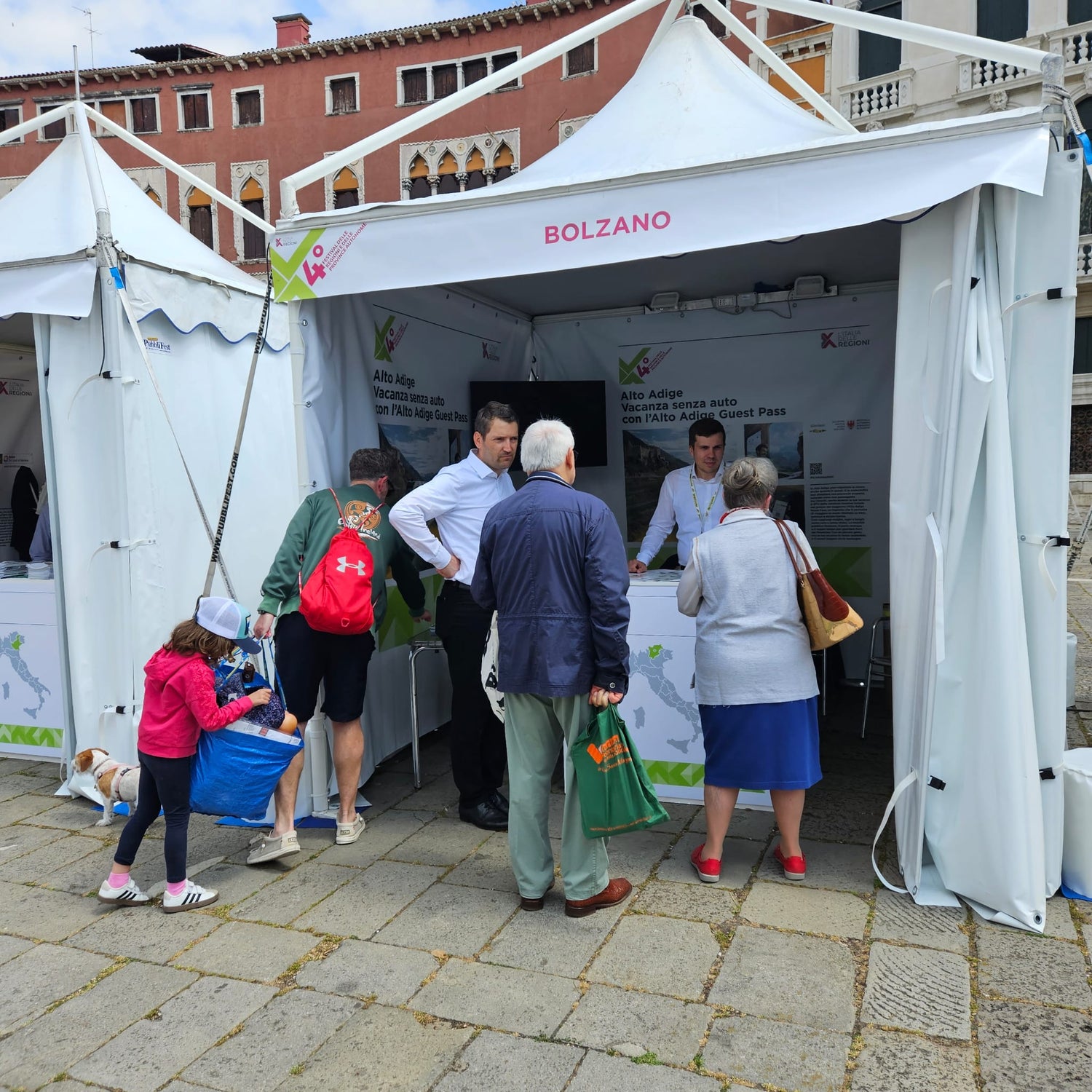 Martin Vallazza (in primo piano con la camicia bianca), direttore del Dipartimento Mobilità e Infrastrutture, allo stand della Provincia autonoma di Bolzano al Villaggio delle Regioni (Foto: USP)
