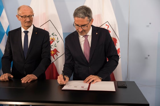 Il presidente Kompatscher firma la dichiarazione d'intenti comune, a sinistra il presidente del Tirolo Mattle (Foto: Land Tirol/Sedlak)