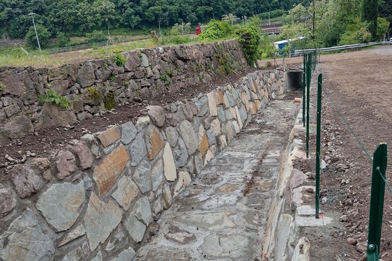 Die Wildbacharbeiter haben den Leitachgraben nördlich vom Bozner Stadtzentrum über eine Strecke von 90 Metern mit einer Künette versehen, die aus Zyklopenmauerwerk mit Beton besteht. (Foto: LPA/Landesamt für Wildbach- und Lawinenverbauung Nord in der Agentur für Bevölkerungsschutz)