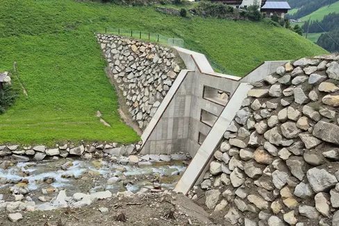 Das Landesamt für Wildbach- und Lawinenverbauung Ost hat am Keilbach eine etwa 12 Meter hohe Fenstersperre mit 4 Austrittsöffnungen errichtet. Die ursprüngliche kleinere Filtersperre an dieser Position musste abgebrochen werden, um ein ausreichendes Volumen des Rückhalteraumes gewährleisten zu können. (Foto: LPA/Landesamt für Wildbach- und Lawinenverbauung Ost in der Agentur für Bevölkerungsschutz)