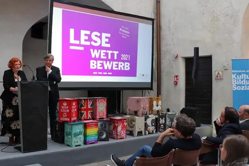 Im Rahmen des Bibliotheksforums 2022 wurde der Südtiroler Ideenwettbewerb zur Leseförderung mit der Vorstellung und Prämierung der Siegerprojekte abgeschlossen. Am Rednerpult: Sigrid Klotz und Markus Fritz vom Amt für Bibliotheken und Lesen (Foto: LPA/Amt für Bibliotheken und Lesen)