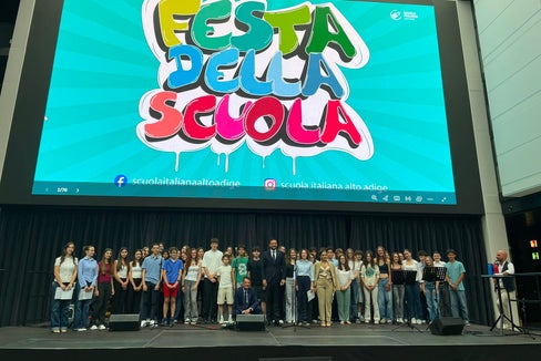 Il vicepresidente e assessore all'Istruzione Marco Galateo (nella foto al centro) posa insieme alle ragazze e ai ragazzi durante la tradizionale Festa della Scuola italiana alla Fiera di Bolzano (Foto: USP/Valentina Failo)