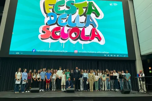 Il vicepresidente e assessore all'Istruzione Marco Galateo (nella foto al centro) posa insieme alle ragazze e ai ragazzi durante la tradizionale Festa della Scuola italiana alla Fiera di Bolzano (Foto: USP/Valentina Failo)