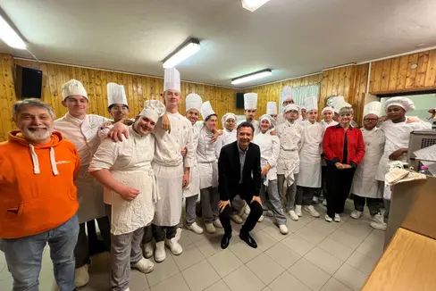 Im Einsatz für einen nachhaltigen Einsatz von Lebensmitteln: Die Schülerinnen und Schüler der Landesberufsschule für das Gastgewerbe C. Ritz mit Direktorin Coretta Ceretta (3. von links), Hauptschulamtsleiter Vincenzo Gullotta (vorne, im schwarzen Anzug) und Giovanni Vultaggio (Direktor der Landestafel/Banco Alimentare). (Foto: LPA)