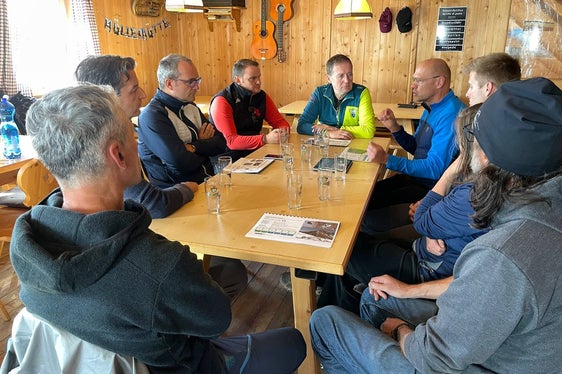 Landesrat Bessone (grüne Jacke) im Gespräch mit Technikern und Hüttenbetreibern (Foto: LPA/Landesvermögensabteilung)