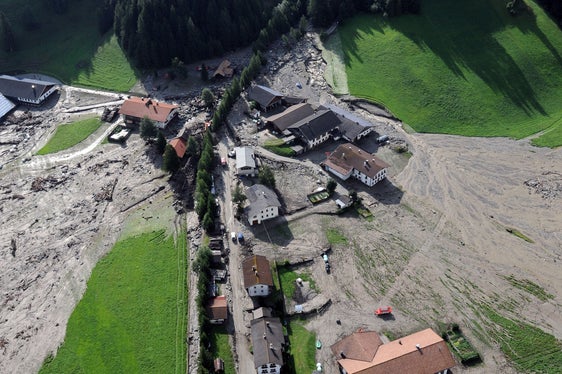 Archivbild: Der Blick auf den Großbergbach und den Weiler Fußendraß am Tag nach der Überschwemmung, am 5. August 2012, zeigt das Ausmaß der Schäden. Im Hintergrund hinter der Baumgruppe erkennbar die Rückhaltesperre, die erst knapp ein Jahr vor dem Unwetterereignis errichtet worden war. (Foto: LPA/Landeswarnzentrum in der Agentur für Bevölkerungsschutz)