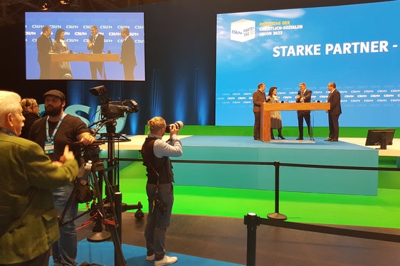 LH Kompatscher (auf der Bühne 3.v.l.) plädierte für Entschlossenheit der Alpenregionen beim Klimawandel: Besser heute als morgen kohlenstoffneutrale Makroregion werden. (Foto: LPA)