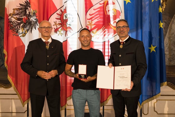 Weil Simone Nettl (Mitte) aus Lana zwei Personen aus einem Fahrzeug auf den Bahngleisen gerettet hatte, überreichten die Landeshauptleute Anton Mattle (links) und Arno Kompatscher (rechts) ihm die Lebensrettermedaille. (Foto: Land Tirol/Sedlak)