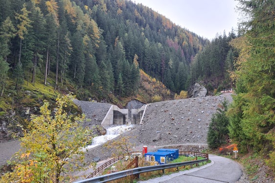 Die Wildbachverbauung hat im Öttenbach in Sarnthein die Sperre aus Stahlbeton um zwei auf nunmehr circa neun Meter erhöht und die Betonsichtfläche zum Teil mit Materialbewegungen und Auffüllungen verdeckt, um sie anschließend noch zu begrünen. (Foto: LPA/Landesam für Wildbach- und Lawinenverbauung Nord)