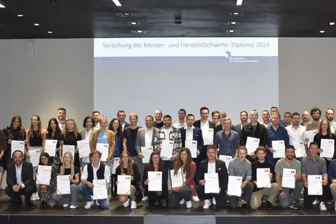 Gruppenbild bei der Diplomfeier: die 13 Meisterinnen, 38 Meister, 6 Handelsfachwirtinnen und 2 Handelsfachwirte mit der Direktorin des Landesamtes für Lehrlings- und Meisterausbildung Cäcilia Baumgartner (vorne, Erste von links) und Landesrat Philipp Achammer (vorne, Zweite von links) (Foto: LPA/Landesamt für Lehrlings- und Meisterausbildung)