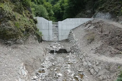 Die Wildbachverbauung hat im Öhlbach in Blumau in der Gemeinde Karneid oberhalb der Gewerbezone Bodner ein Rückhaltebecken mit einem Rückhaltevermögen von circa 10.000 Kubikmeter Geschiebematerial errichtet. (Foto: LPA/Landesamt für Wildbach- und Lawinenverbauung Süd in der Agentur für Bevölkerungsschutz/Hansjörg Prugg)