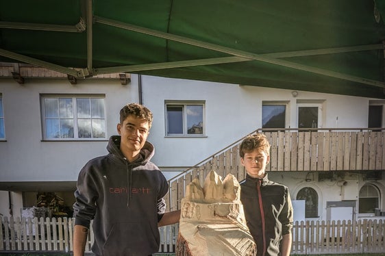 Jonas Puff (links) und David Pitscheider (rechts), Schüler der 4. Klasse der Fachrichtung Bildhauerei der Landesberufsschule für Kunsthandwerk La Prufesciunela St. Ulrich, mit ihrer Skulptur. (Foto: LPA/Patrick Senoner)