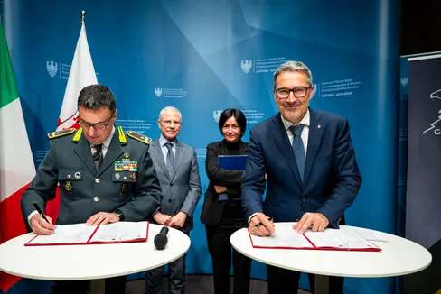 Der regionale Kommandant der Finanzwache für Trentino-Südtirol, General Gavino Putzu (links) und Landeshauptmann Arno Kompatscher (rechts) unterzeichneten vor Regierungskommissar, Präfekt Vito Cusumano und Landesrätin Ulli Mair (im Hintergrund) die Vereinbarung zur Organisation von Wettbewerbsverfahren für Personal mit Zweisprachigkeitsnachweis. (Foto: LPA/Fabio Brucculeri)